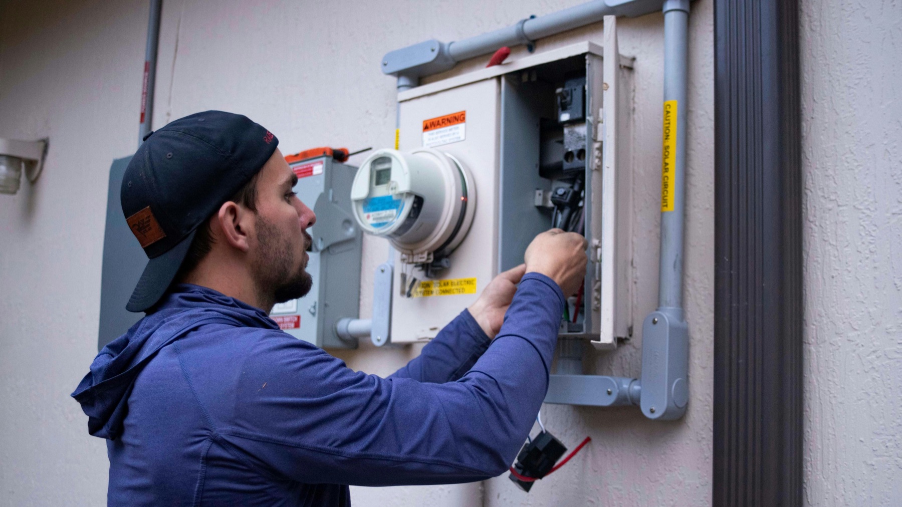 An electrician working on a panel